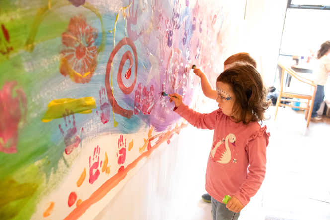 children painting wall mural